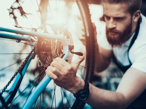 Ein Mann repariert ein Fahrrad.