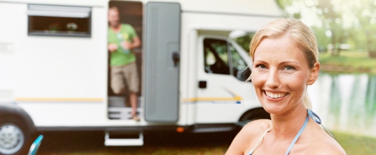 Frau steht vor Wohnmobil