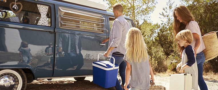 Eine Familie belädt ihr Wohnmobil für den Urlaub