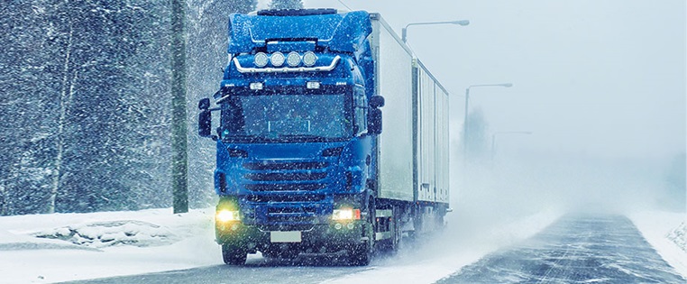 Lkw fährt auf verschneiter Straße