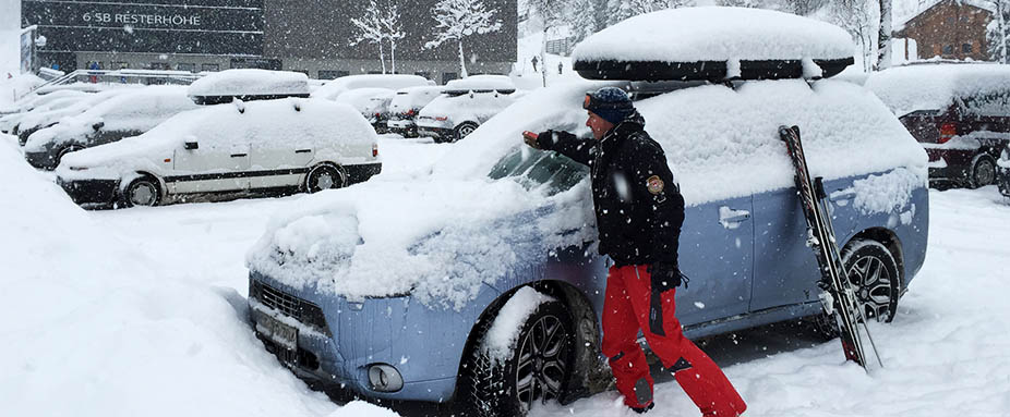 Mann befreit Auto von Schnee
