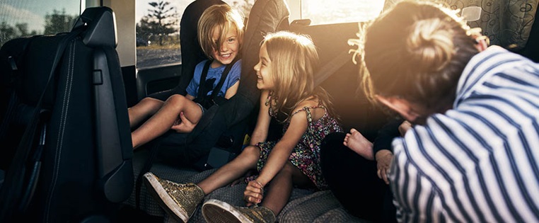 drei Kinder auf dem Rücksitz eines Autos