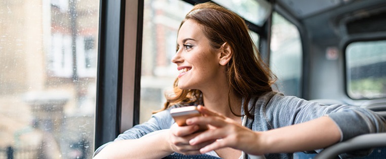 Frau mit Handy im Bus