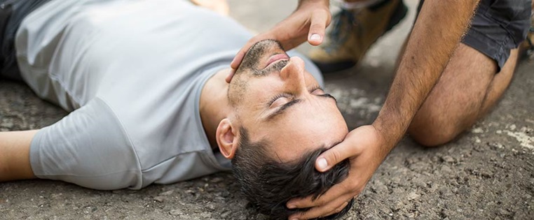 Erste Hilfe wird geleistet. Mann liegt auf der Straße