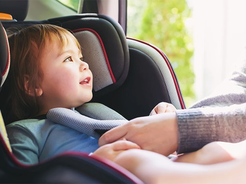 Kleines Kind wird im Autositz angeschnallt