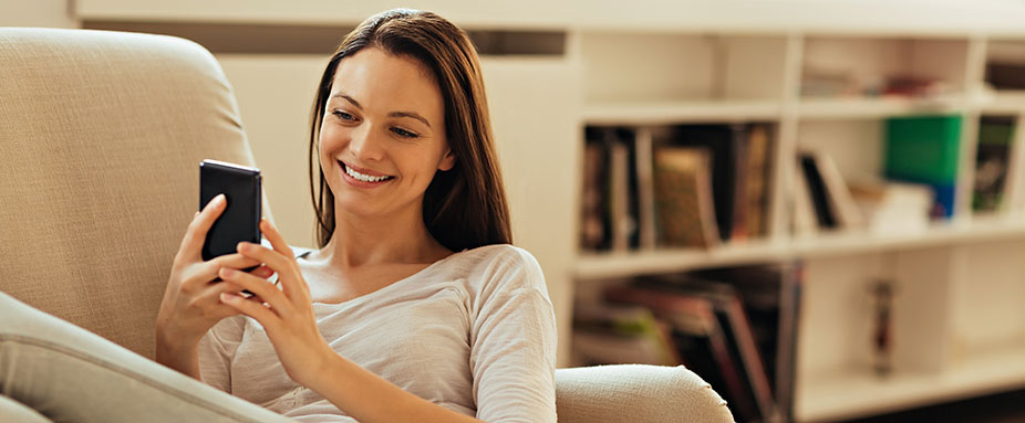 Frau mit Telefon auf Couch