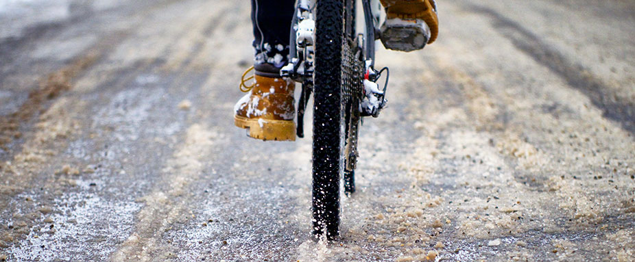 Fahrradfahrer von hinten im Schnee