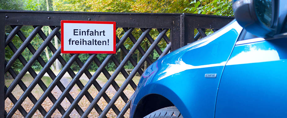 Auto parkt vor einer Hauseinfahrt