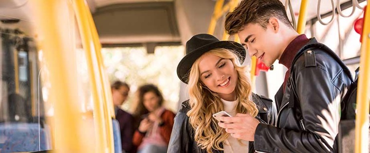 Paar im Bus schaut ein ein Smartphone