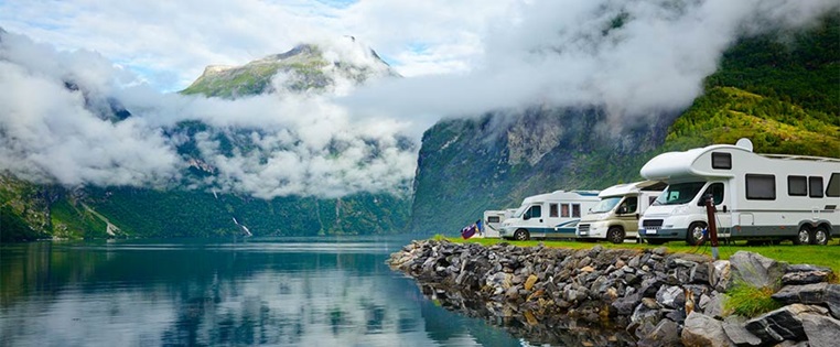 Wohnmobile stehen am Wasser