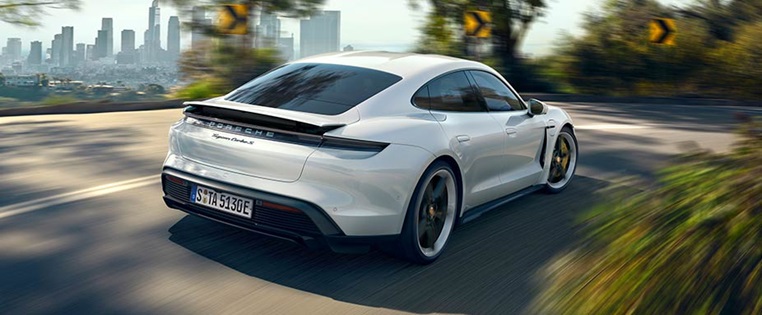 Heckansicht des Porsche Taycan fahrend