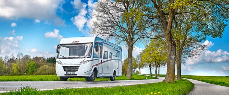 Wohnmobil fährt durch sommerliche Landschaft