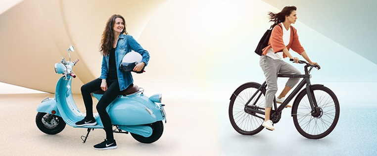 Frau auf E-Bike und Frau auf E-Motorroller