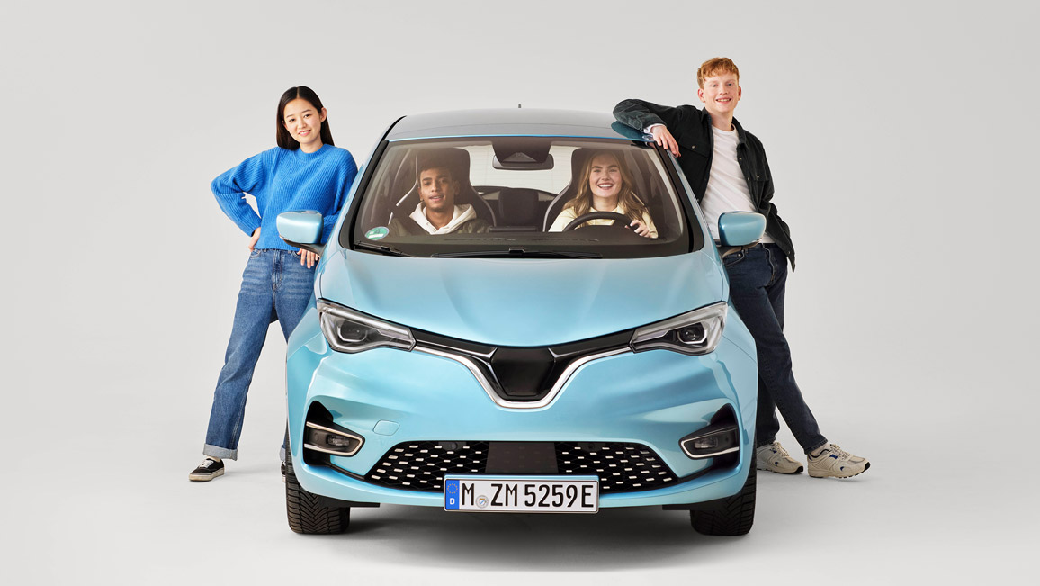 Zwei junge Leute in einem Auto, zwei junge Leute lehnen am Auto