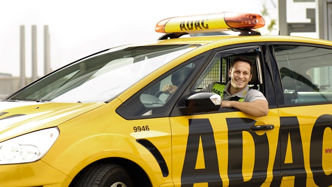 ADAC Strassenwachtfahrer schaut freundlich aus dem Auto