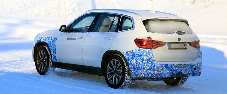 BMW iX3 fahrend von hinten