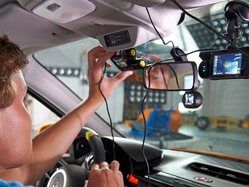 Ein ADAC-Tester bringt eine Dashcam an der windschutzscheibe an