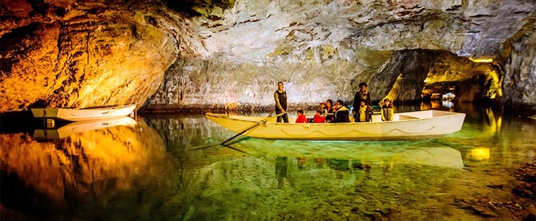 Menschen fahren mit einem Boot auf dem Lac Souterrain in der Schweiz