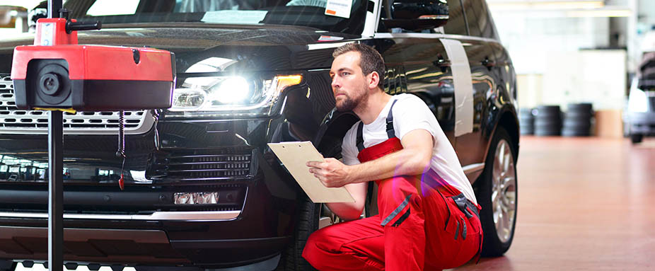 Mechaniker führt einen Lichttest am Auto durch