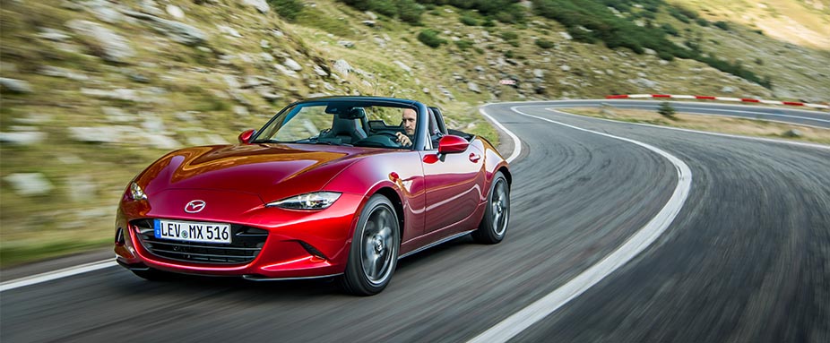 Roter Mazda MX5 fahrend von vorne