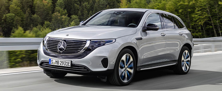 Silberner Mercedes EQC fahrend von der Seite