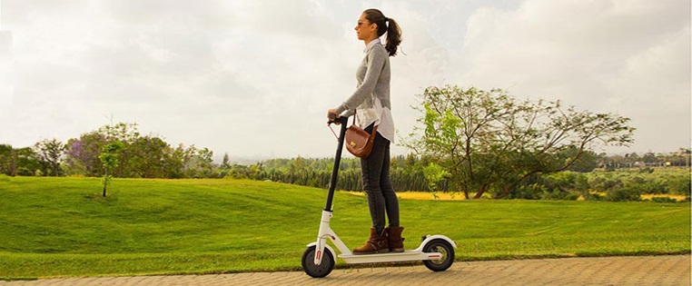 Eine frau fährt mit einem E-Scooter von Xiaomi der zurück gerufen wurde Rückruf