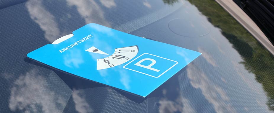 Parkscheibe liegt auf einem Amarturenbrett im Auto