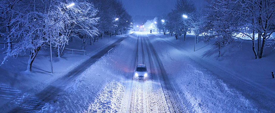 Luftaufnahme von einem Auto auf einer verschneiten Straße