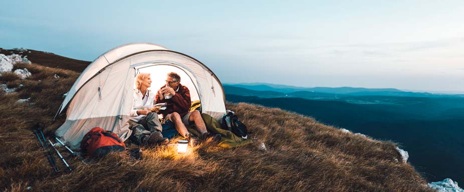 Paar beim Camping mit Zelt am Abend