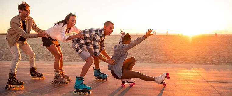 Freunde fahren Inline Skates bei Sonnenuntergang
