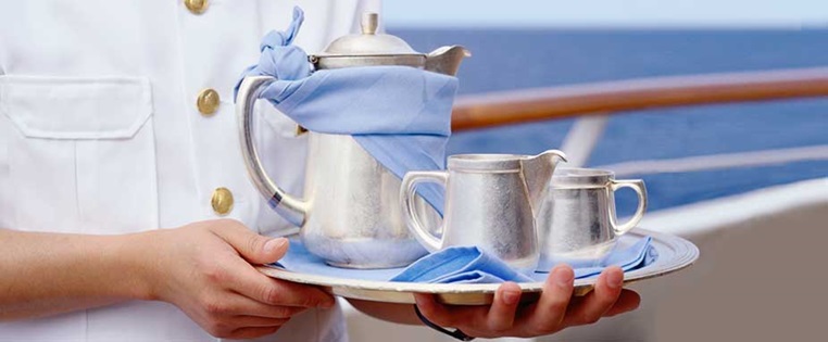 Bedienung auf einem Kreuzfahrtschiff reicht Kaffee