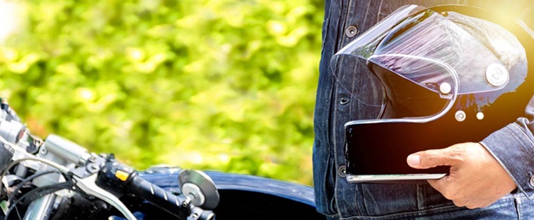 Mann hält Motorradhelm unter Arm