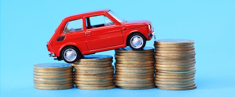 Spielzeugauto fährt Treppe aus Euromünzen hoch