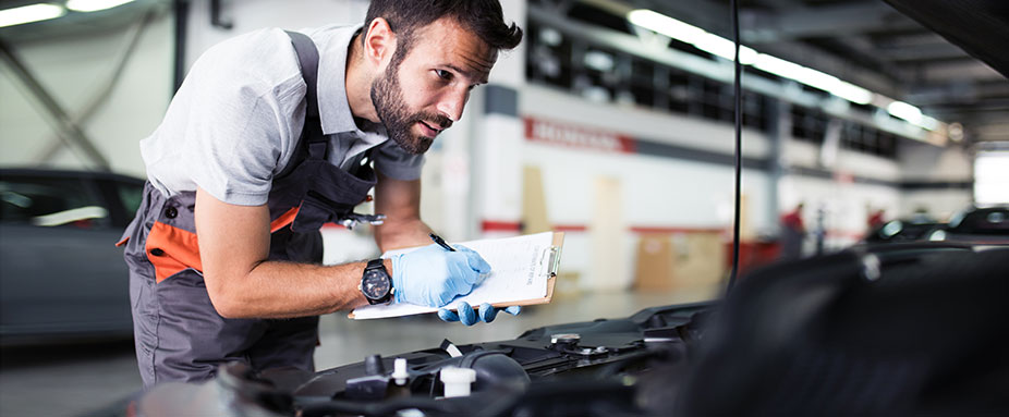 Mechaniker schaut in den Motor eines Autos