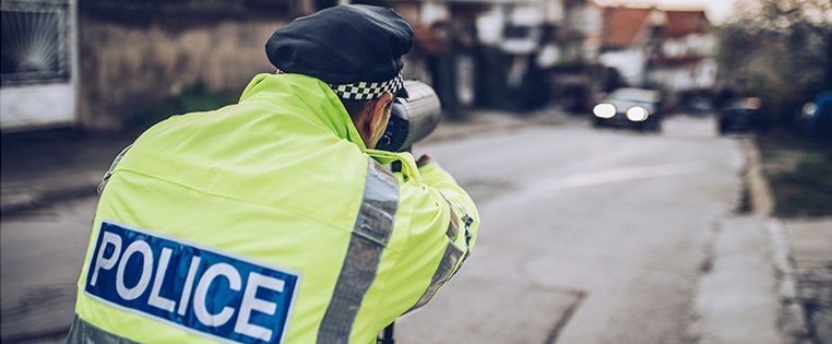 Englischer Polizist zielt mit Radarpistole auf Auto