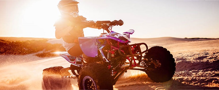 Quad fährt über Sandpiste