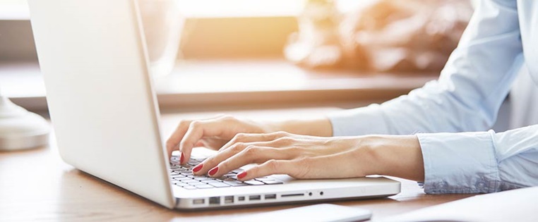 Frau tippt auf Laptop