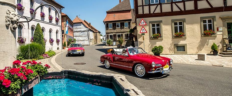 zwei Oldtimer fahren durch die Stadt