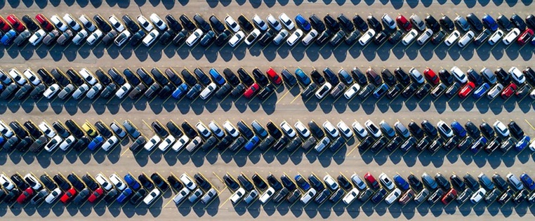 Parkplatz mit vielen, neuen, bunten Autos, die auf den Export warten