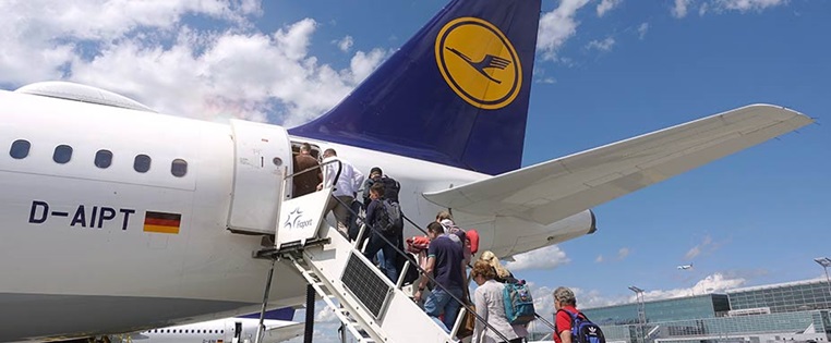 Passagiere betreten über Treppe eine Lufthansamaschine