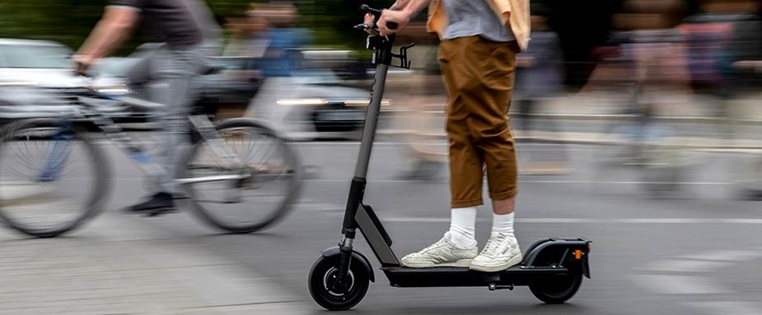 E-Scooter Fahrer in Bewegung in der Stadt
