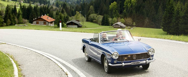 OldtimerCabriolet mit älterem Ehepaar unterwegs auf Passstraße in Europa