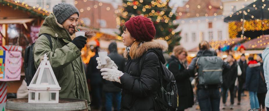 Paar trinkt Glühwein am Weihnachtsmarkt