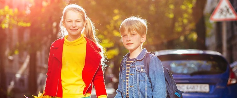 Kinder auf dem Schulweg an der Straße