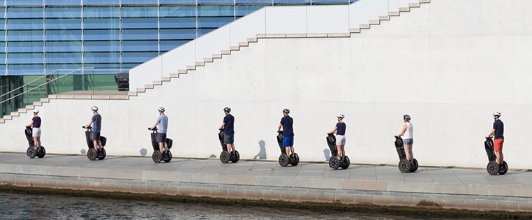 Eine gruppe Segwayfahrer on Tour in Berlin an der Spree entlang