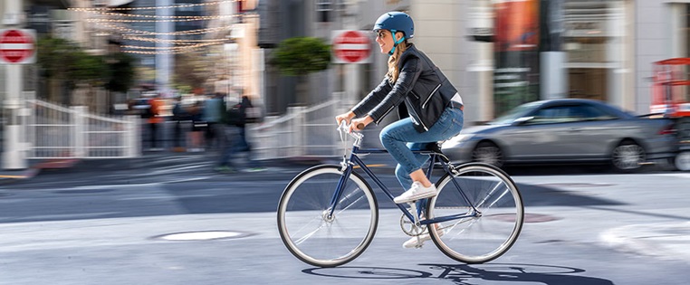 Frau fährt mit ihrem Fahrrad durch die Stadt