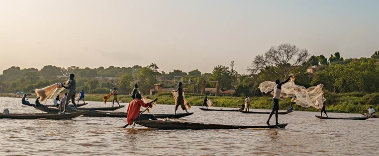 Fischer in Booten mit Netzten an einem Fluss