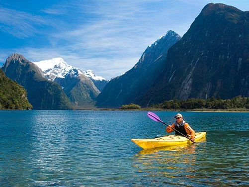 Mann fährt Kajak im Fiordland National Park in Neuseeland