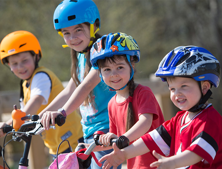 Kinder mit Fahrradhelmen sitzen auf Fahrrädern